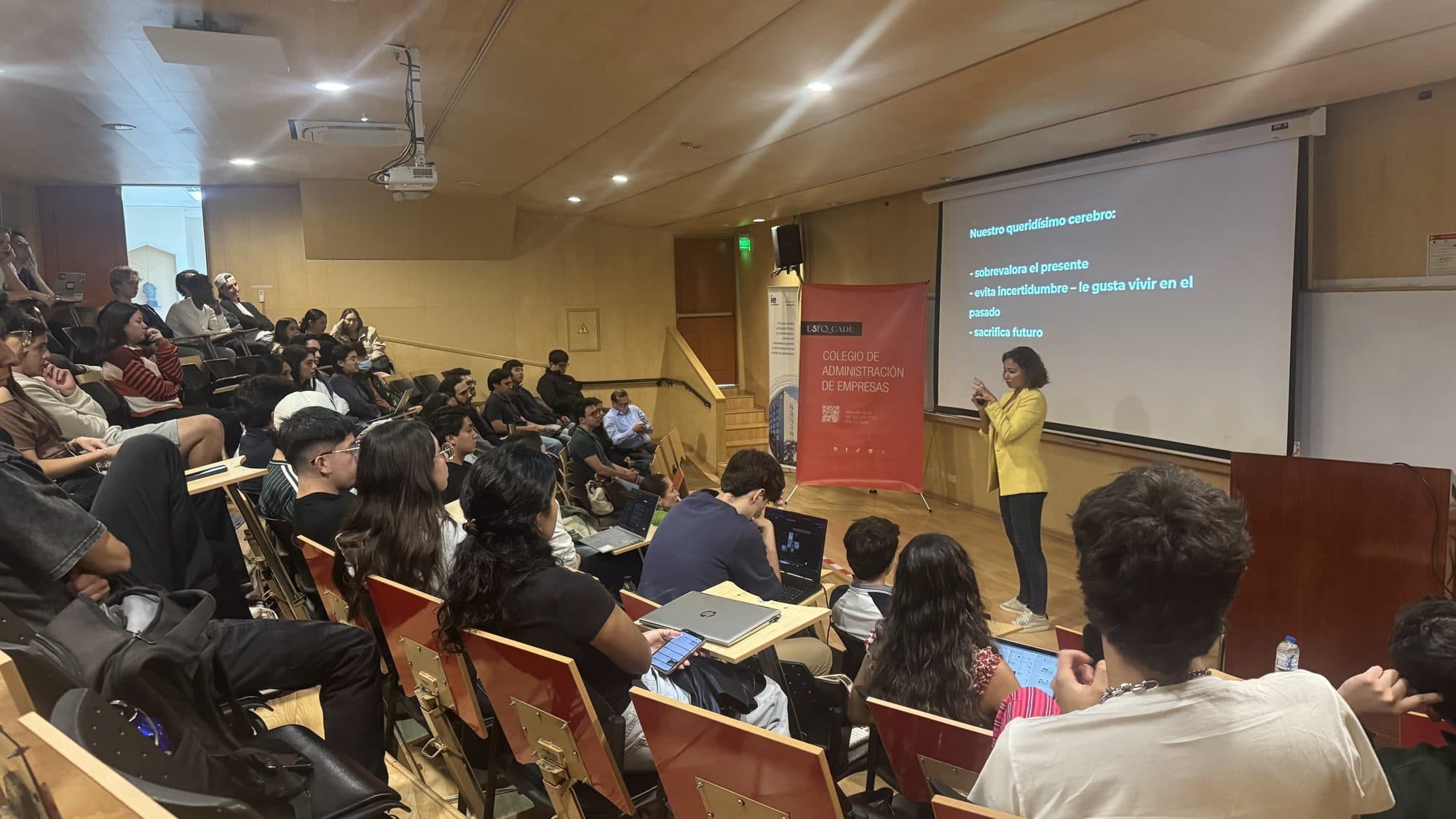 Sam Hernández García lecturing on how the brain makes decisions to a full university lecture hall