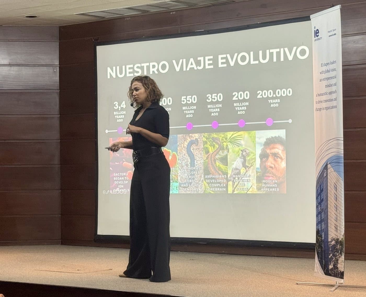 Sam on stage presenting “Our evolutionary journey”